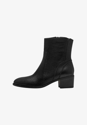 Botte de cheville en cuir noir avec une finition texturée, bout rond et un petit talon bloc. Dotée d'une fermeture éclair sur le côté pour un enfilage facile.