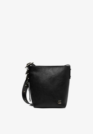 Černá kožená kabelka ve tvaru koše s nastavitelným popruhem, kovovou sponou a malým kovovým logem v pravém dolním rohu přední strany.