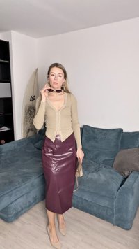 Beige langärmliges Oberteil mit Spitze, kombiniert mit einem hochgeschnittenen burgunderroten Leder-Bleistiftrock, taupefarbigen Schuhen mit Absatz und Sonnenbrille.