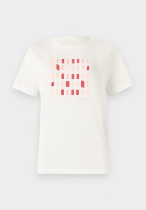 T-shirt en coton blanc présentant un motif géométrique de formes rectangulaires dans des teintes de rose et de rouge. Encolure ras du cou et manches courtes.