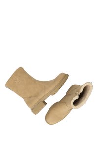 Beige fusk-suede ankstövlar med rund tå, ribbad gummisula och fuskpälsfoder. Sidogjord och logotypdetalj på hälen.