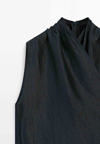 Ærmeløs sort kjole med høj halsudskæring og lynlåslukning bagpå, lavet af struktureret stof.