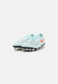 Crampons de football bleu clair avec une semelle noire et blanche, un dessus texturé et un logo Swoosh rose proéminent. Comprend un design à lacets pour un bon ajustement.
