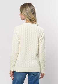 Kreemikas kaablisilmusega kudumiga kampsun ribaga varrukate ja alaosaga. Omaduseks tekstuurse mustriga ja lõdvestunud lõige. Sobib vabaaja kandmiseks.