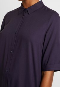 Mörkblå kortärmad skjorta med knappar i lätt tyg med klassisk krage, som har en slät yta och standardstorlek.