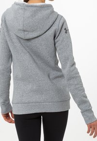 Sudadera con capucha gris, hecha de tejido suave, con un dobladillo y puños acanalados, con un logotipo en el hombro izquierdo y un corte relajado.