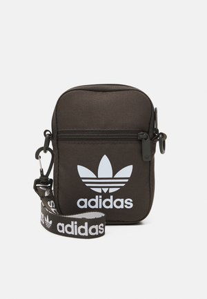 Pochette noire Adidas avec poche avant zippée, logo blanc et bandoulière de marque détachable avec clip, conçue pour transporter de petits objets.
