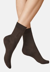 Dunkelbraune Knöchelsocken aus einem glatten, elastischen Material mit einem gerippten Bündchen oben und einem nahtlosen Design für maximalen Komfort.