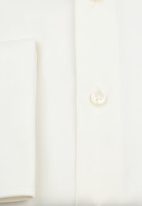 Witte overhemd met een gladde textuur, een schuine zak en een witte knop met een viergaatjesontwerp op de sluiting.