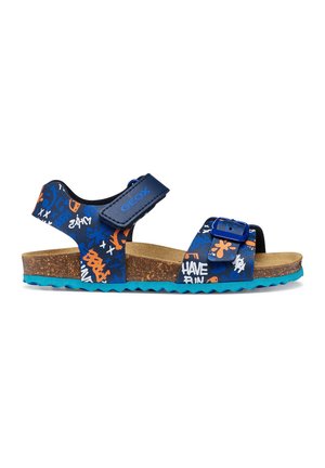 Sandalia azul para niños con suela de corcho, hebilla ajustable y tiras de Velcro, decorada con patrones estilo graffiti en naranja, blanco y azul.