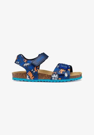 Sandale bleue pour enfants avec semelle en liège, boucle réglable et bandes Velcro, décorée de motifs style graffiti orange, blanc et bleu.