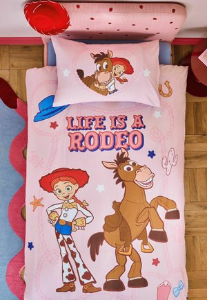 Ropa de cama rosa con un dibujo animado de una vaquera y un caballo, texto "Life is a Rodeo,", diseños de sombrero vaquero, herradura, cactus y placa de sheriff.