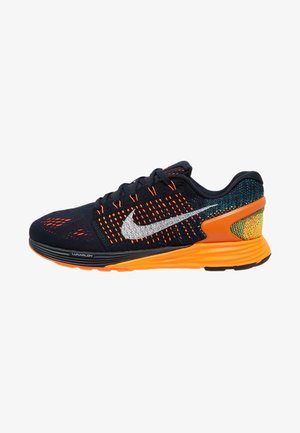 Chaussure de course Nike noire et orange avec le logo Swoosh blanc, tige en mesh, semelle rembourrée et marquage "Lunarlon" sur la semelle intermédiaire.