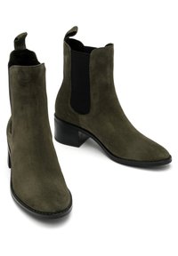 Zielone zamszowe botki za kostkę z wąskim noskiem, elastycznymi bocznymi panelami, uchwytami do zakładania i osadzonym obcasem. Gładka tekstura i smukły design.