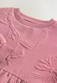 Felpa rosa chiaro con superficie texture, motivo a foglia in rilievo e scollatura e polsini rigati.