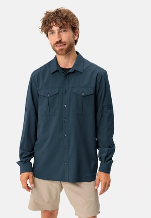 Camicia a maniche lunghe in tessuto blu navy scuro, con due tasche sul petto, chiusura frontale con bottoni e polsini arrotolati. Leggera e con una texture liscia.
