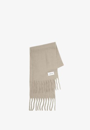 Écharpe beige en matériau doux, avec des bords frangés et une petite étiquette avec le texte "ARCTIC FOX" d'un côté.