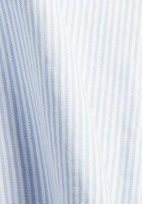 Tissu tissé rayé bleu clair et blanc avec des lignes verticales et de légers plis de texture.