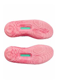 Pink athletic shoe outsoles featuring textured rubber patterns, with a central turquoise accent labeled "Under Armour."
