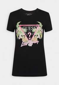 T-shirt noir à manches courtes avec logo triangle rose, accents floraux et texte "Guess U.S.A." et "Los Angeles" sur le devant.