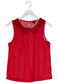 Blouse rouge sans manches avec bordure en dentelle florale au col et aux emmanchures, suspendue sur un cintre blanc sur fond blanc.