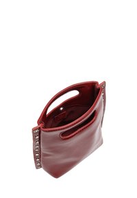 Czerwona skórzana torba na ramię o gładkiej teksturze, zaokrąglonym wierzchu i bocznych uchwytach. Posiada dekoracyjne srebrne ćwieki wzdłuż jednej strony.
