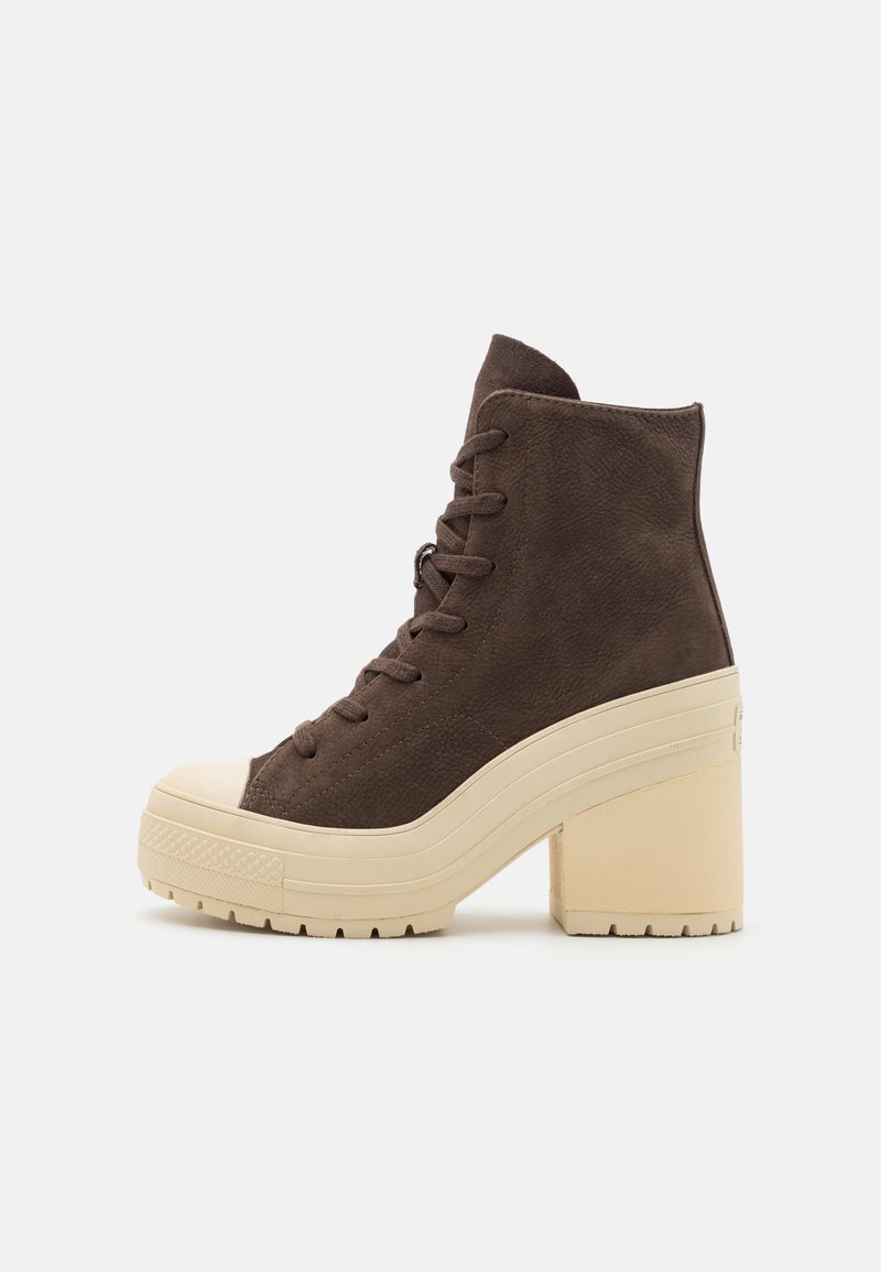 Brown suede ankle boot with a cream rubber toe cap and chunky heel. Features lace-up design and textured outsole for grip.