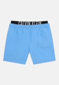 Ανοιχτό μπλε σορτς με ελαστική ζώνη μέσης, μία πίσω τσέπη και ορατή εσωτερική ζώνη μέσης με μαύρη ετικέτα Calvin Klein.