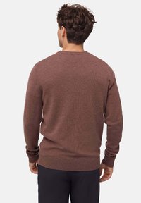 Brązowy sweter z dzianiny z okrągłym dekoltem, długimi rękawami oraz ściągaczami na rękawach i u dołu. Gładka tekstura, bez widocznych wzorów czy akcentów.