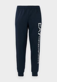 Navy jogger pants with an elastic waistband, cuffed ankles, and white printed branding along the left leg. Soft, matte fabric texture.