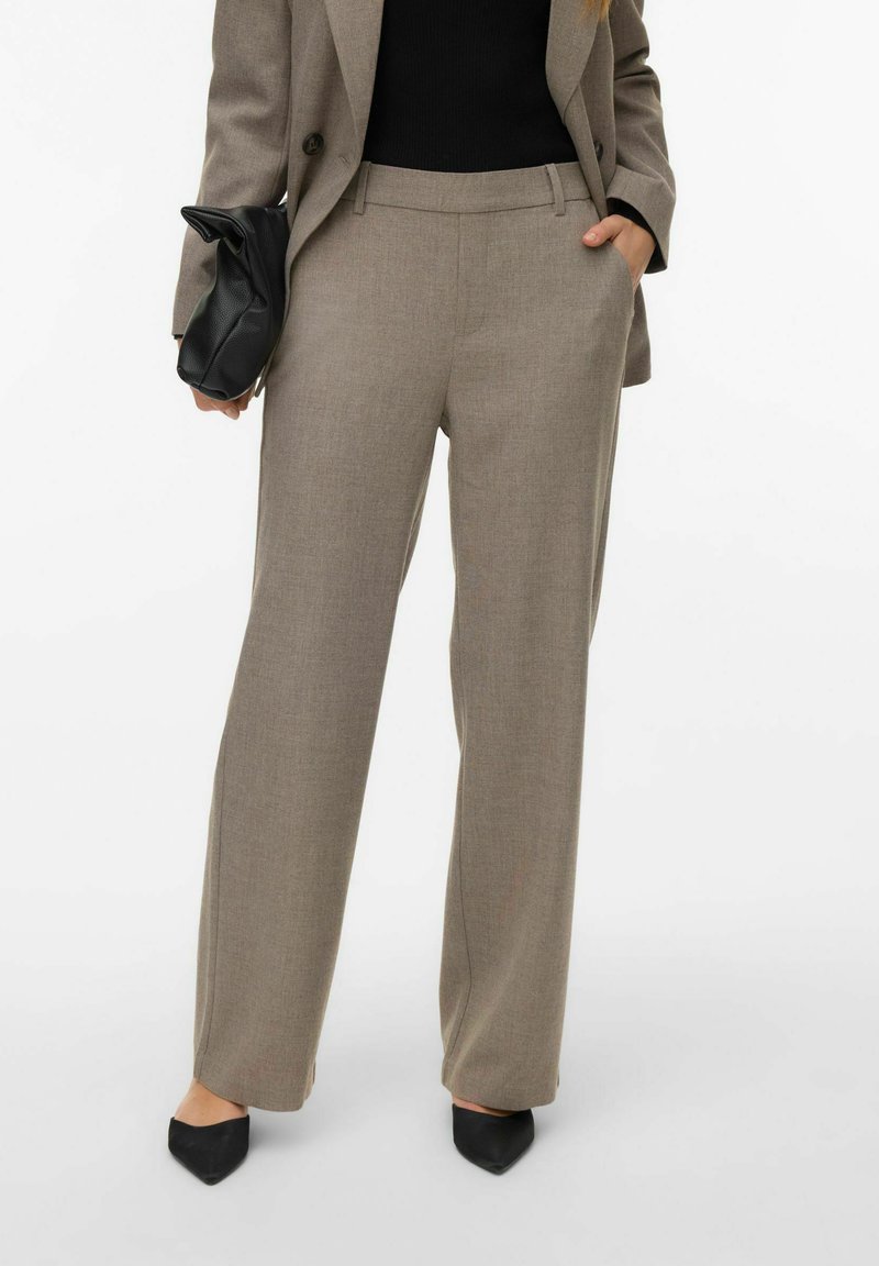 Valget pruunid kohandatud püksid tekstuurse kangaga, sirge säärega lõikega, vööaasade ja küljetaskutega. Täiendatud mustade aksessuaaridega.