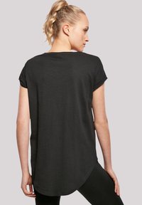 Schwarzes kurzärmliges T-Shirt, von hinten präsentiert, mit abgerundetem Saum und weicher Textur. Einfaches Design ohne sichtbare Muster oder Akzente.