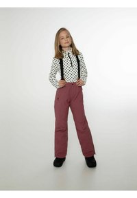 Lapsi on pukeutunut valkoiseen, pitkähihaiseen paitaan, jossa on mustia pilkkuja, yhdistettynä burgundinpunaisiin hiihtohousuihin, joissa on mustat henkselit ja vetoketjulliset taskut. Mustat saappaat täydentävät asua.