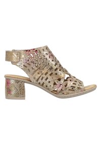 Open-toe, lace-up sandal in metallic gold with decorative floral cutouts, medium block heel, and smooth beige footbed.