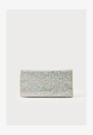 Pochette rectangulaire argentée couverte de strass étincelants et de sequins sur un fond clair uni.
