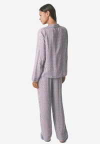 Pajama zestaw z nadrukiem w lekkim materiale z geometrycznym wzorem kolorowych prostokątów. Bluzka z długim rękawem i luźne spodnie.