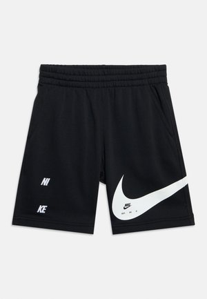 Shorts noirs Nike avec taille élastique, poches latérales, et grand logo swoosh blanc avec le texte "NIKE" à l'avant.