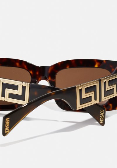 Skilpaddeskjell solbriller med gull geometrisk detaljering på templene, med brune linser og glatte, blanke rammer. Versace-merke inkludert.