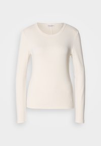 Langermet T-skjorte i kremfarget bomull, med rund hals, tettsittende design og en liten logodetalj nær kanten. Glatt tekstur.