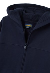 Sudadera con cremallera en azul marino, con capucha forrada de tejido tipo waffle y etiqueta de la marca "essentials" visible en amarillo en el interior del cuello.