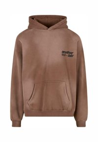 Rjava hoody iz mehkega blaga, z zadnjim žepom, rebrastimi manšetami in kapuco. Vključuje črn logotip na levi prsni strani.