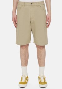 Beige shorts polven pituudelta, valmistettu puuvillasta, suoranlahkeinen malli, jossa on kaksi etutaskua ja nappikiinnitys vyötäröllä.