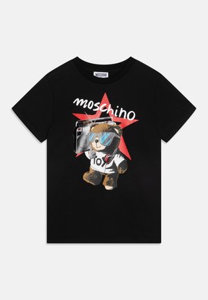 Sort T-shirt med korte ærmer med en teddybjørn, der bærer solbriller og hovedtelefoner, holder en boombox, med en rød stjerne og teksten "Moschino" ovenover.
