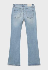 Ljusblå denimjeans med lätt utsvängda ben, två bakfickor och en vit etikett på midjebandet.