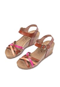 Bruine en roestbruine leren wedge sandalen met kruisbanden en een gesp. Kurken wedge hak, gevoerd voetbed en gestructureerde zool.
