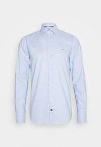 Blaue karierte Langarmbluse mit Button-Down-Kragen, die ein Logo auf der Brust trägt. Hergestellt aus leichtem Stoff mit einer glatten Textur.