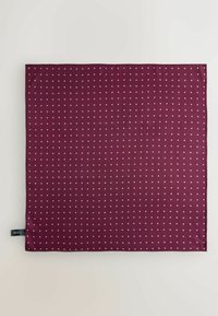 Štvorcová tmavomodrá látka s drobnými rovnomerne rozmiestnenými bielymi bodkami a čiernou značkou na spodnej ľavej strane.