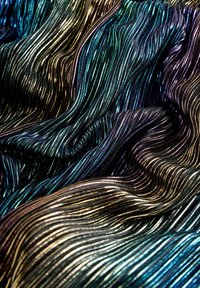 Tessuto metallico intrecciato che presenta motivi ondulati e fluidi in nero, blu scuro e tonalità iridescenti, con una texture liscia e lucida.
