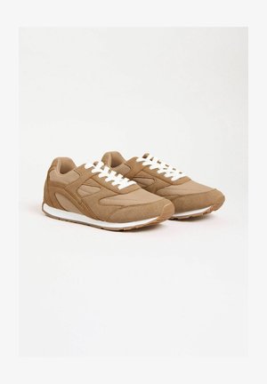 Pantofi sport bej din material textil, cu accente din piele întoarsă, șireturi albe, vârf rotunjit și talpă exterioară din cauciuc texturat.