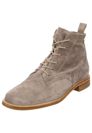 Bottines en daim gris clair avec un bout arrondi, un laçage à l'avant et un petit talon empilé. Coutures visibles le long de la semelle.